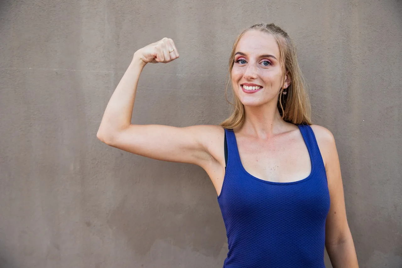 woman in blue flexing arms