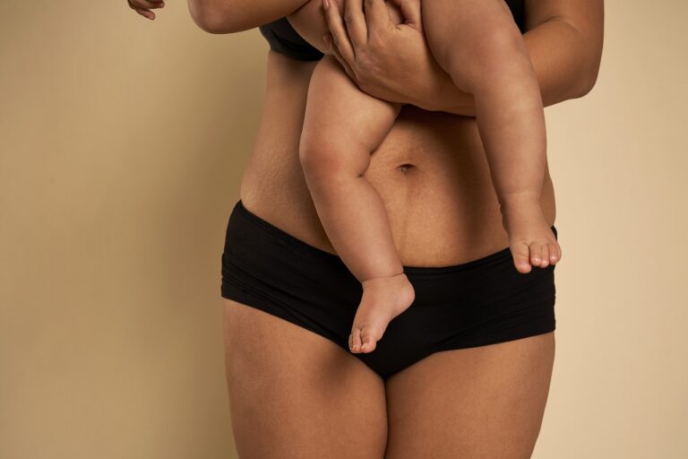 close up of woman in black underwear carrying baby