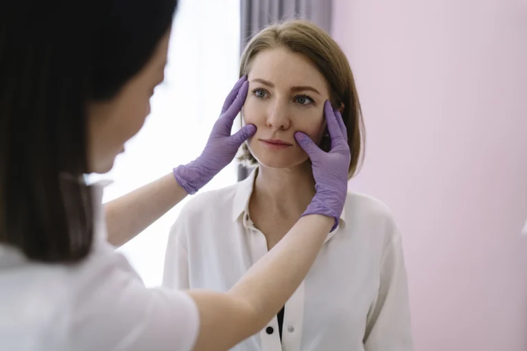 woman getting her face checked by doctor
