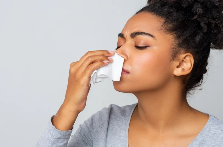 african american woman blowing her nose gently