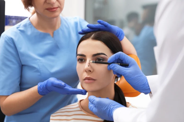 plastic surgeon and assistant preparing patient for surgery