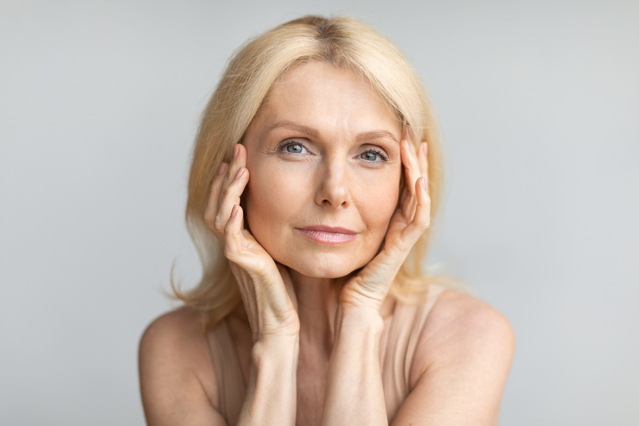 old blonde woman resting hands on face
