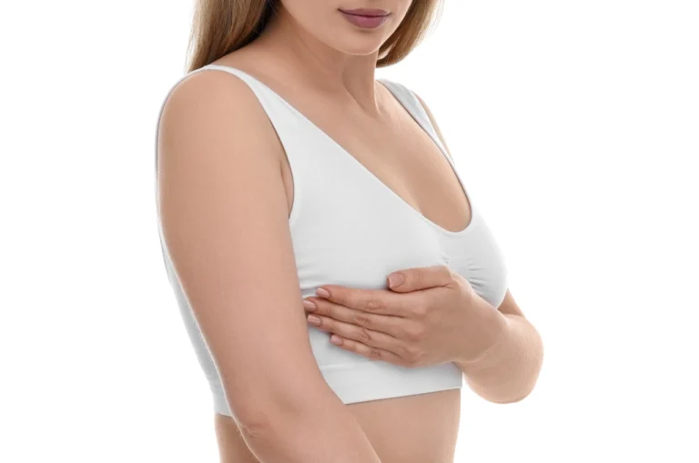 woman wearing a white compression bra gently touching her chest